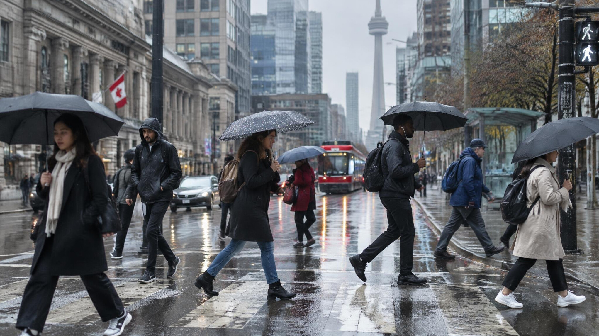 Pedestrians with umbrellas crossing a rainy city street